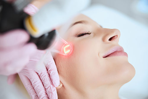 Close up portrait of a young woman patient receiving a laser treatment in a spa